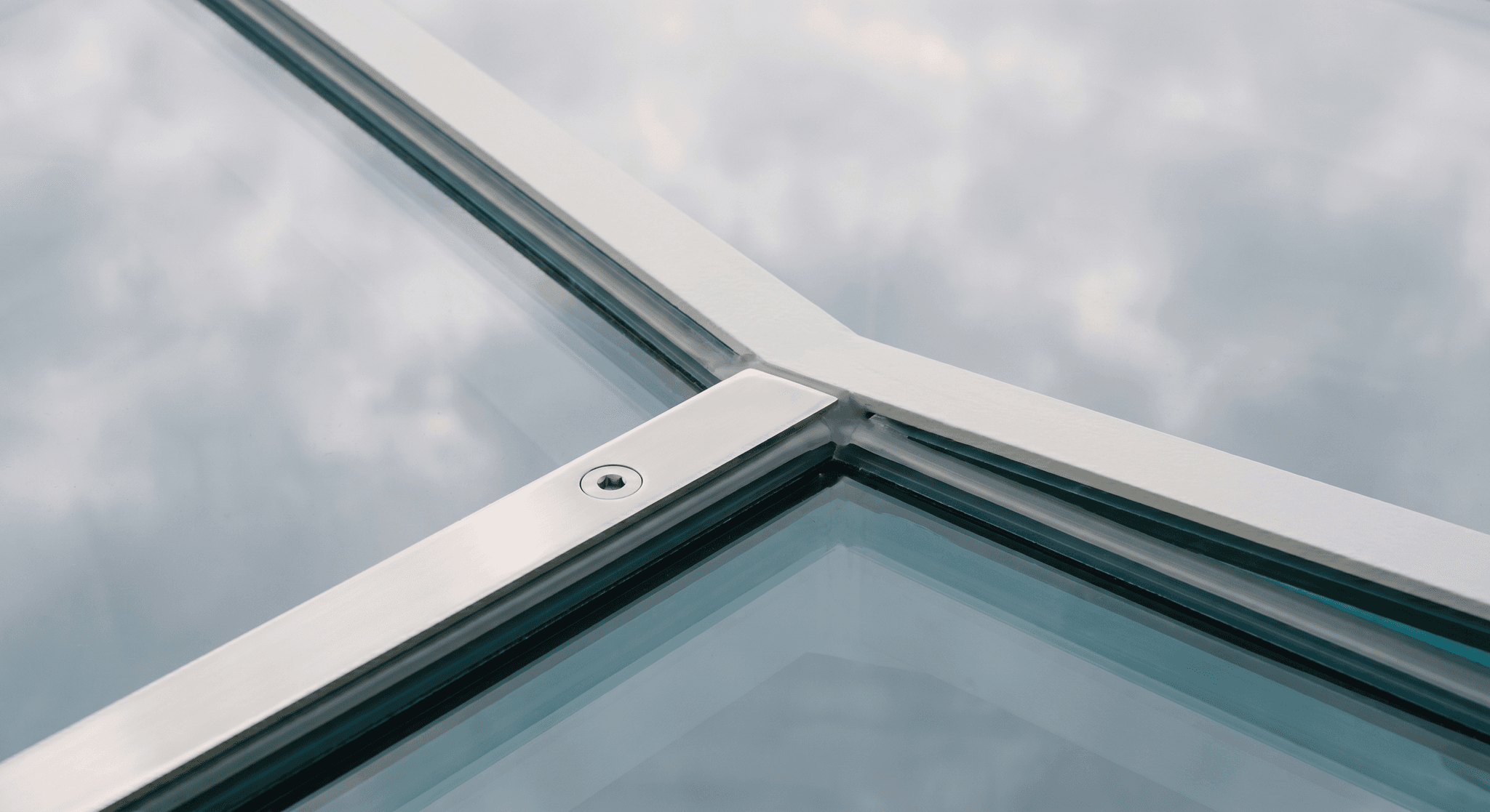 Detail of intersection of three triangular glass panels, polished stainless steel plate with machined bolt, structural silicone joint