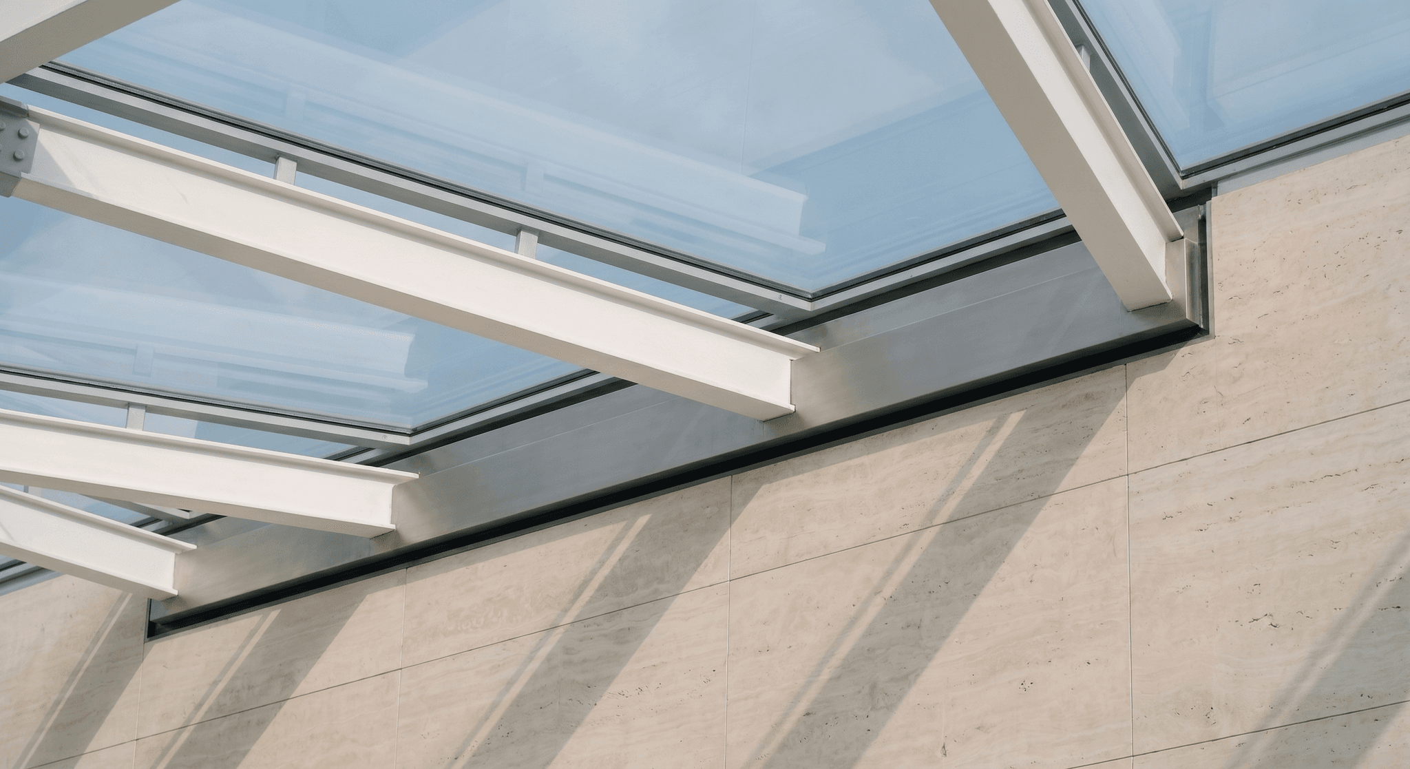 Detail of diagrid springline against travertine wall, stainless anchorage profile, raking shadows of the chords projected on the stone