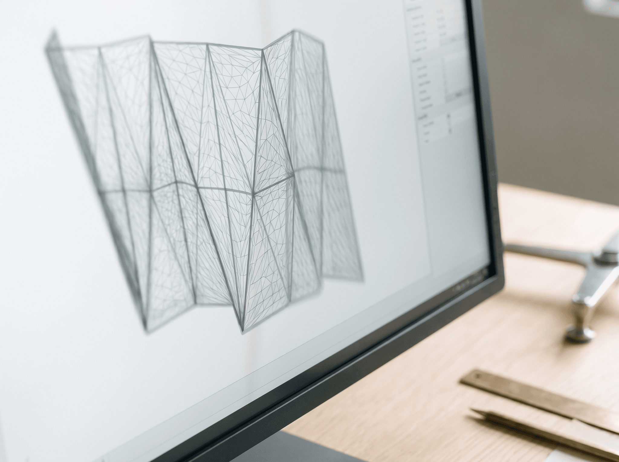 Macro workstation screen, illegible 3D parametric wireframe, free-form triangulated geometry, anthracite bezel