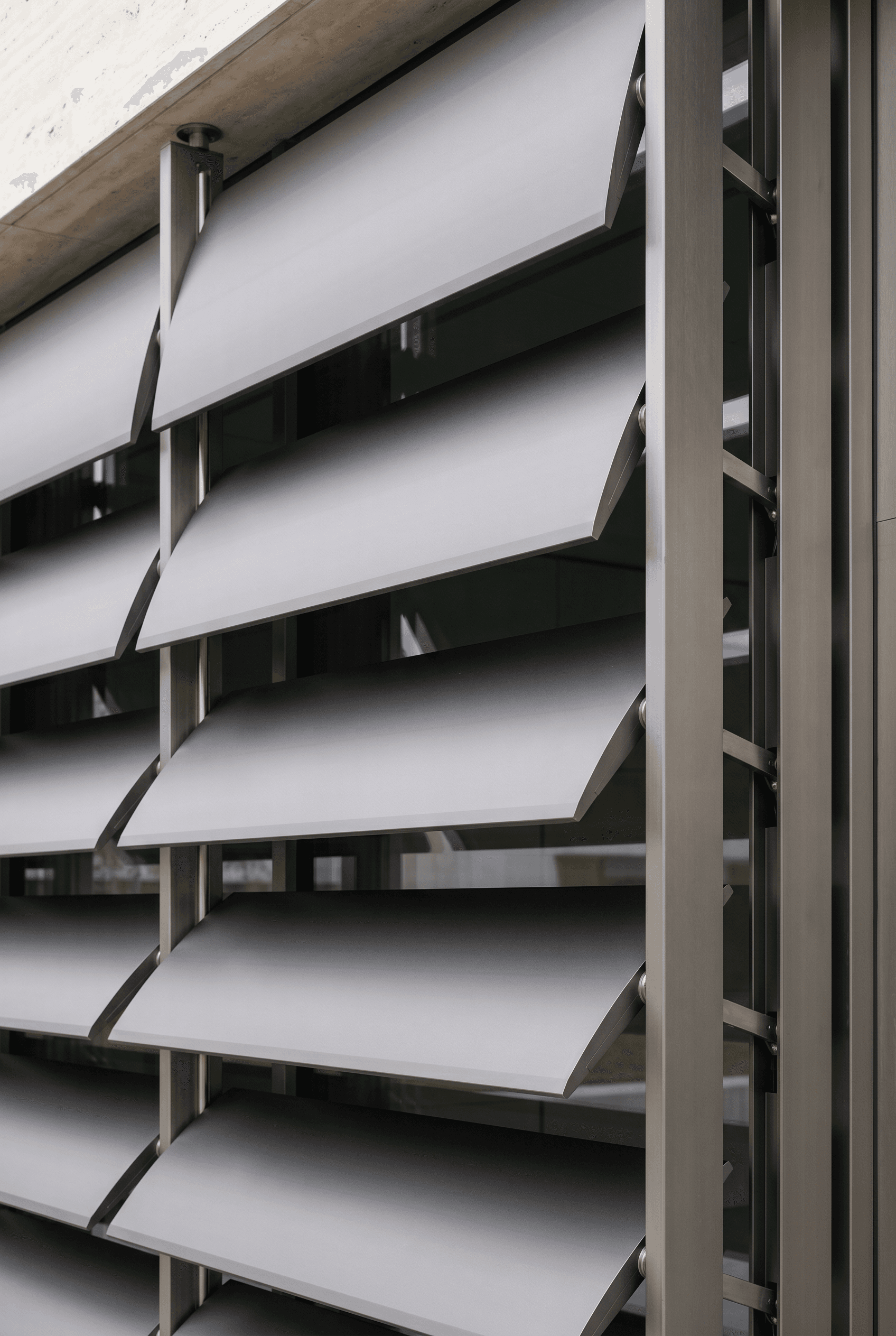 Detail of motorised brise-soleil louvres, anodised anthracite, drive arm and actuator hidden in stile, staggered partial open position