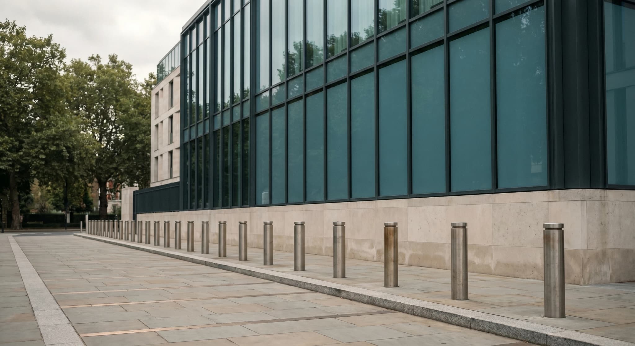 Institutional facade with UFC 4-010-01 standoff perimeter and stainless security bollards
